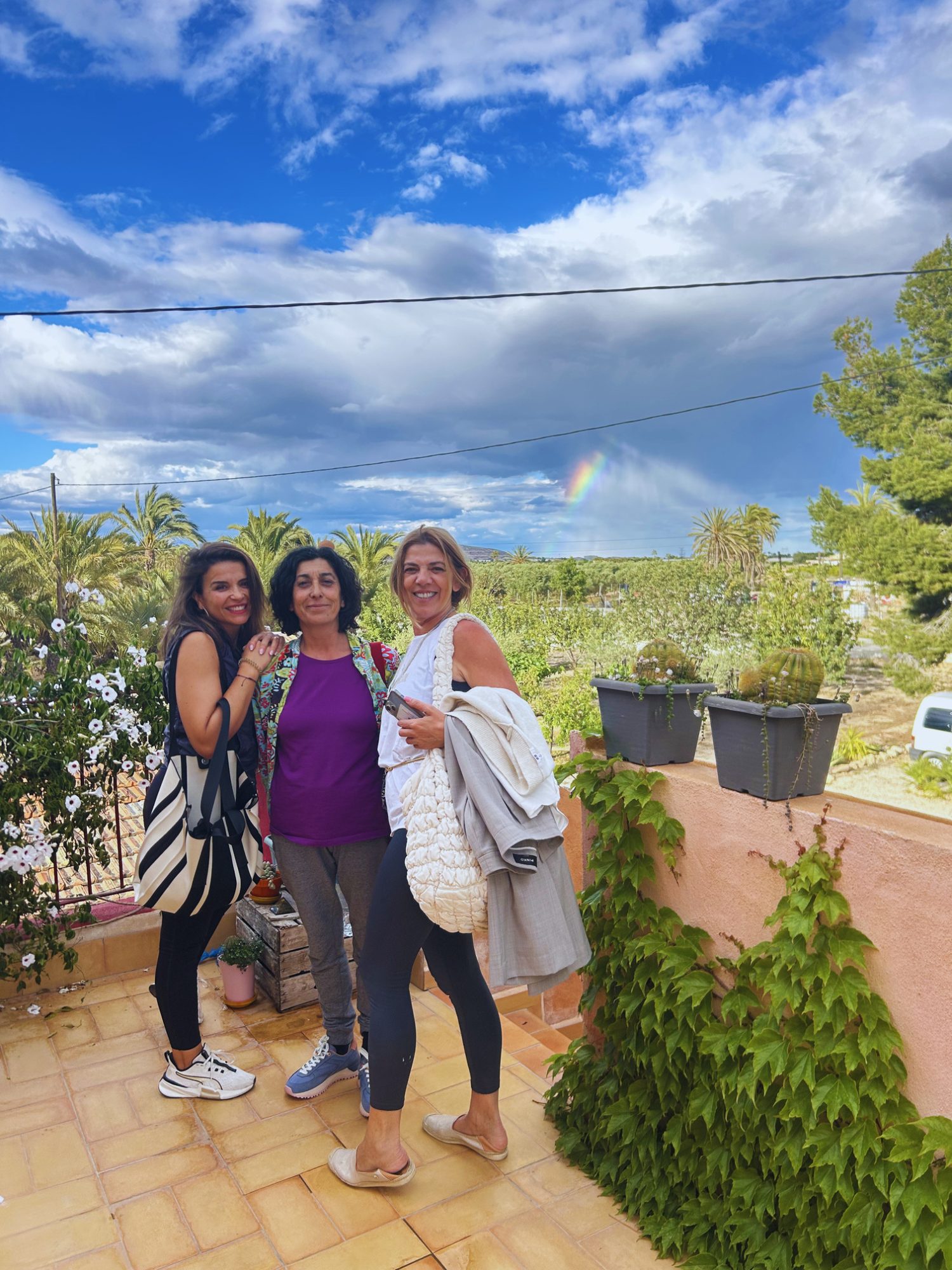 Tres alumnas en la terraza con arcoíris
